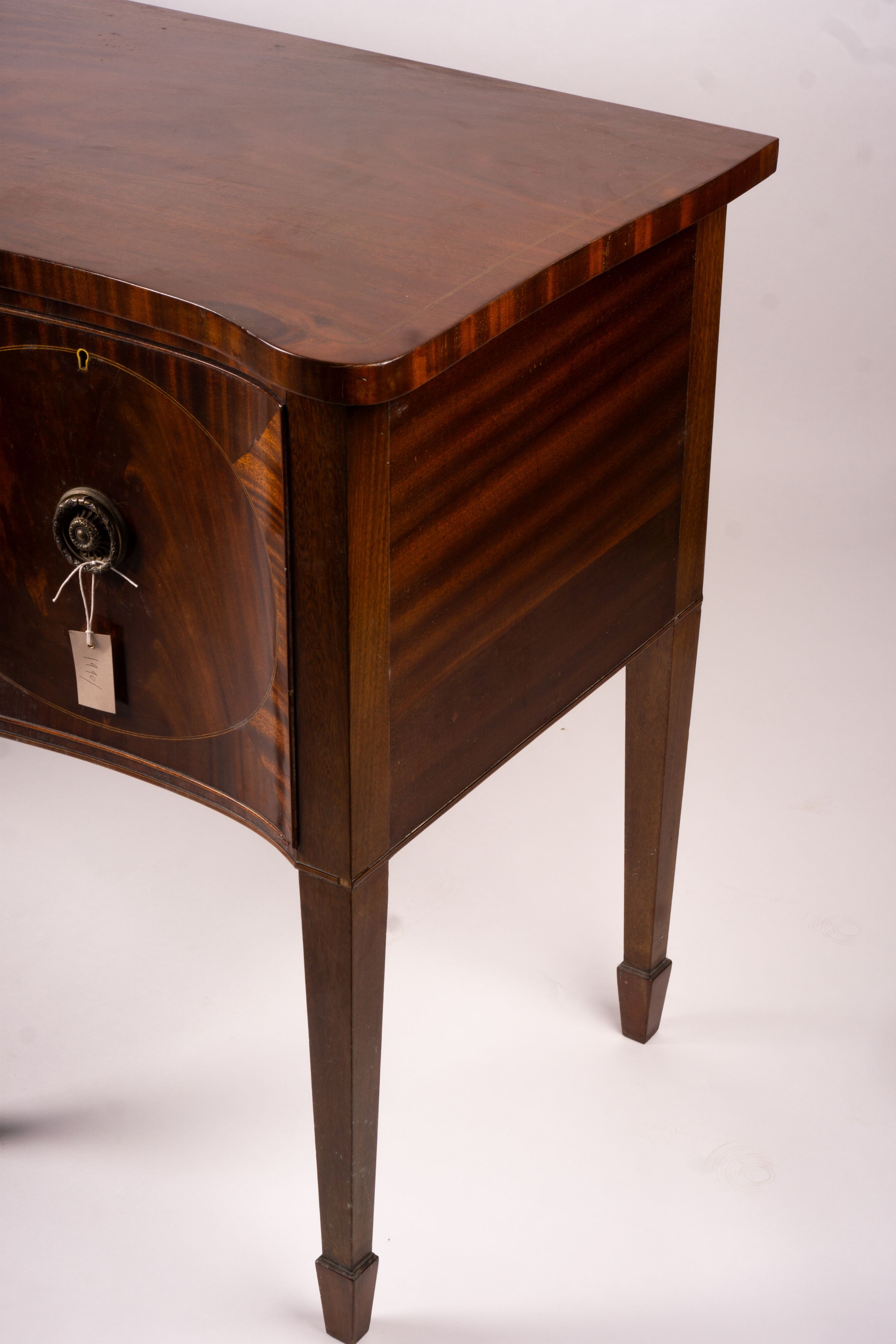 A George III style mahogany serpentine sideboard on square tapered legs, width 184cm, depth 63cm, height 93 cm